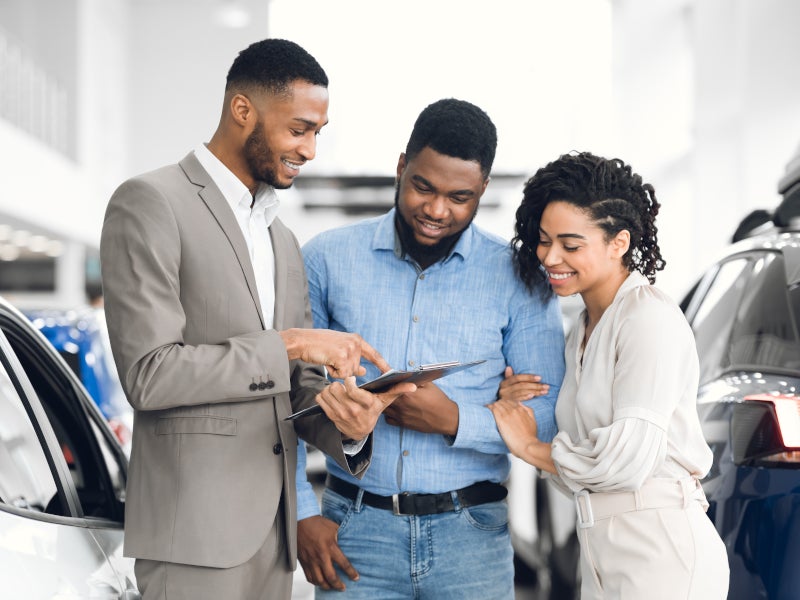Happy couple shopping for their new car